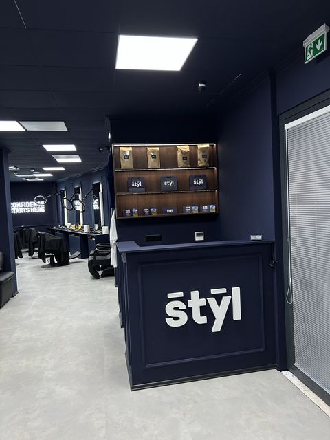 Reception desk with the Štýl logo at the entrance of the barbershop in Bratislava-Rača