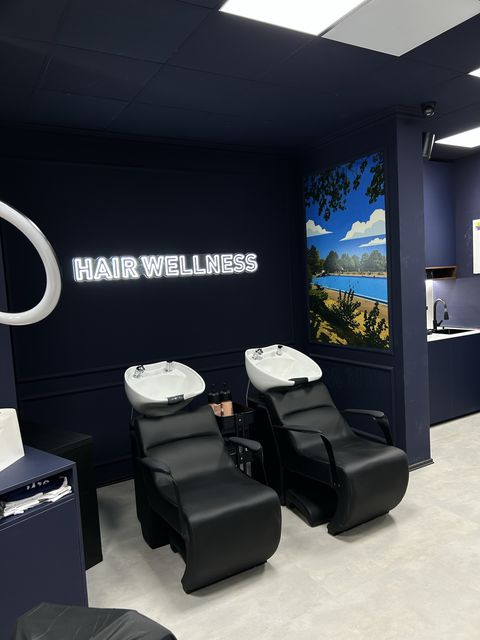 Backwash basins under the 'Hair wellness' sign at Barbershop Štýl